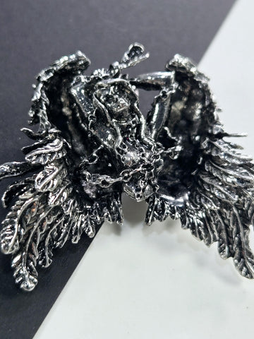 a close-up view of a detailed, intricate metal sculpture with a textured, organic appearance.