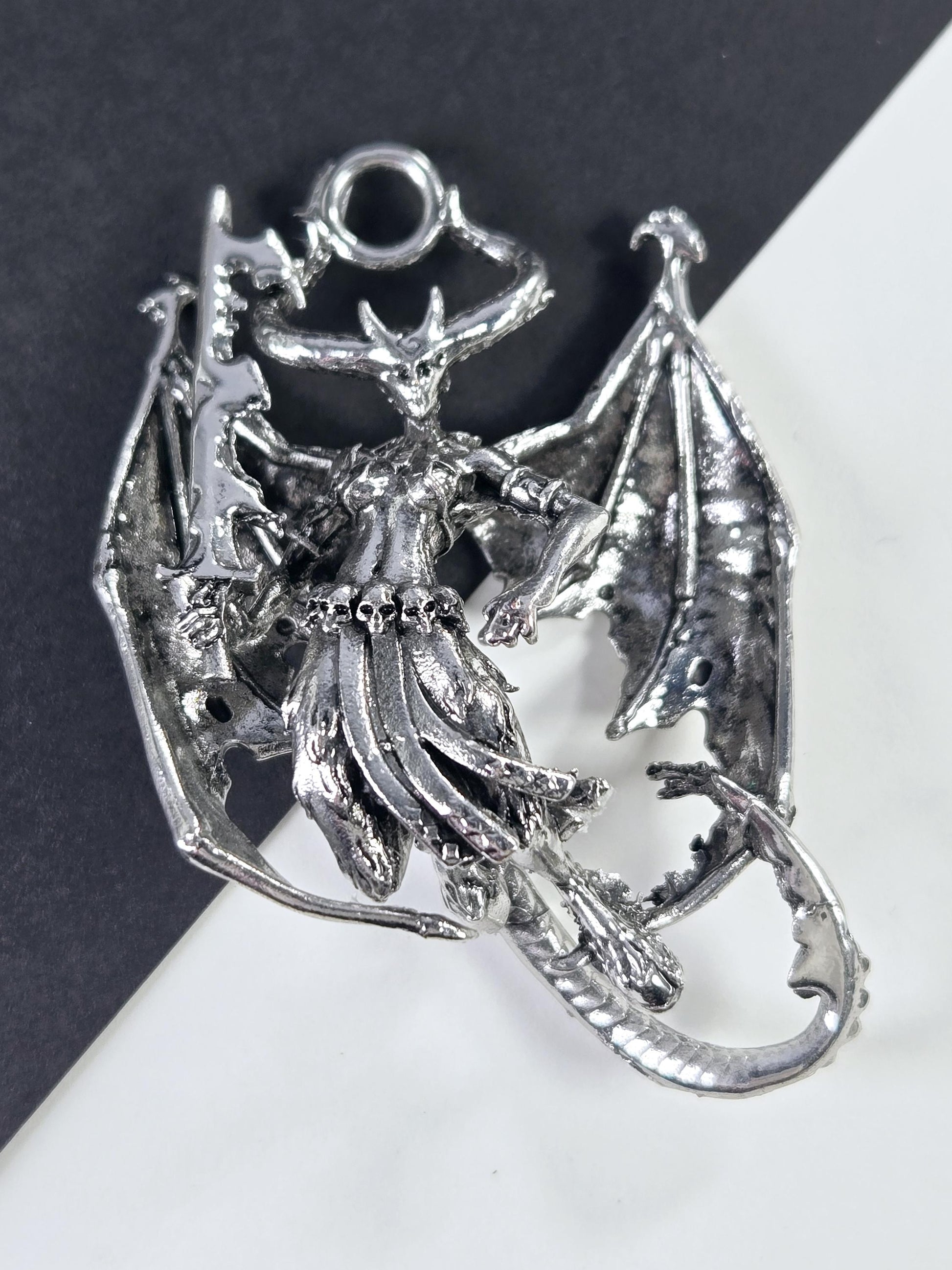 A silver-colored metal dragon figurine is shown in the image.