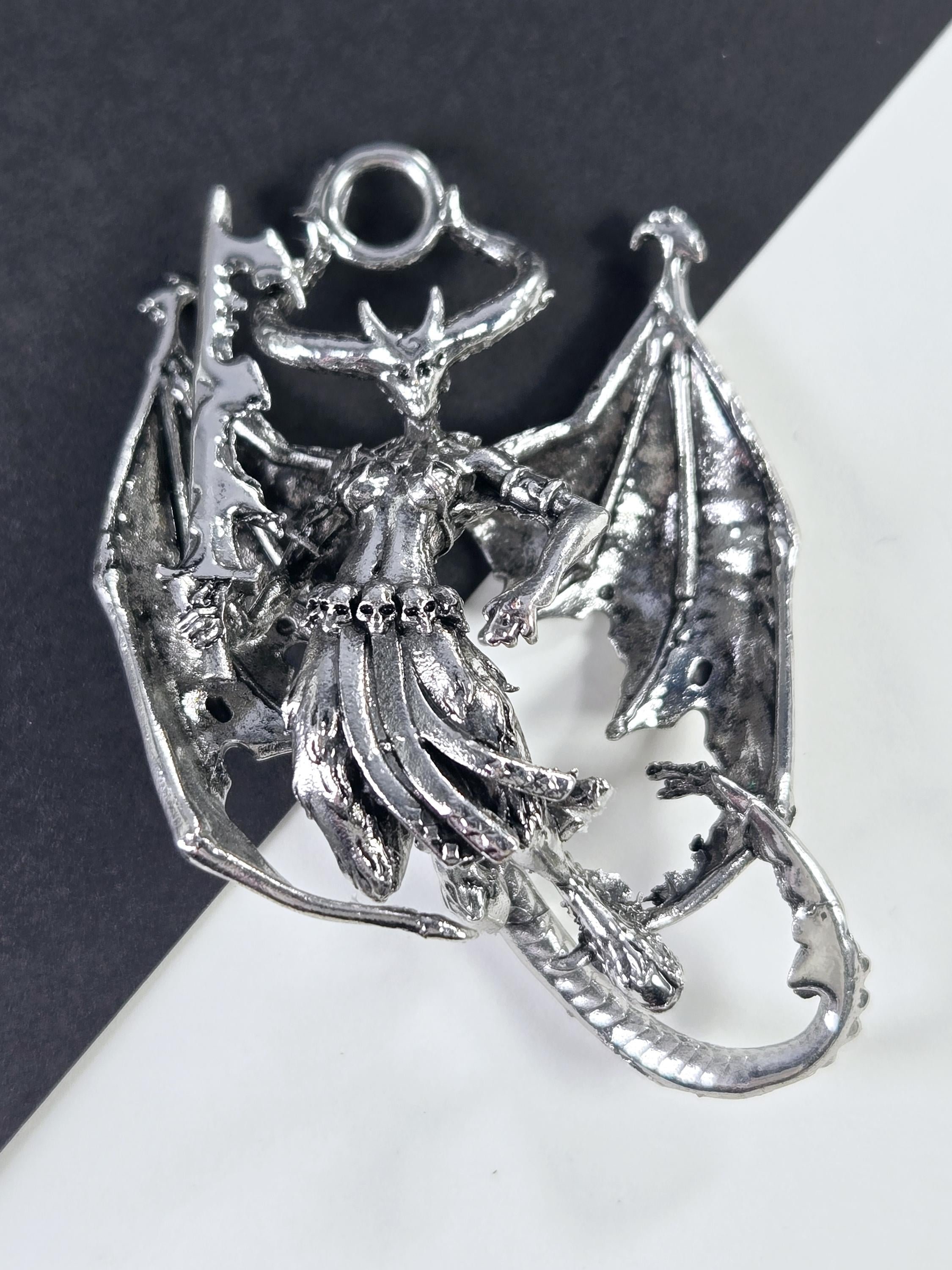 A silver-colored metal dragon figurine is shown in the image.