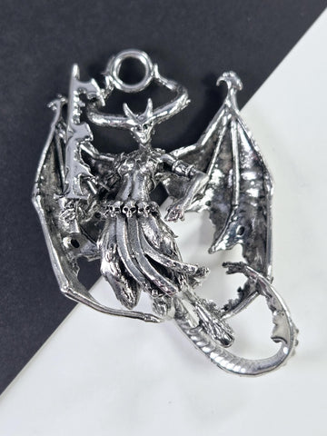 A silver-colored metal dragon figurine is shown in the image.