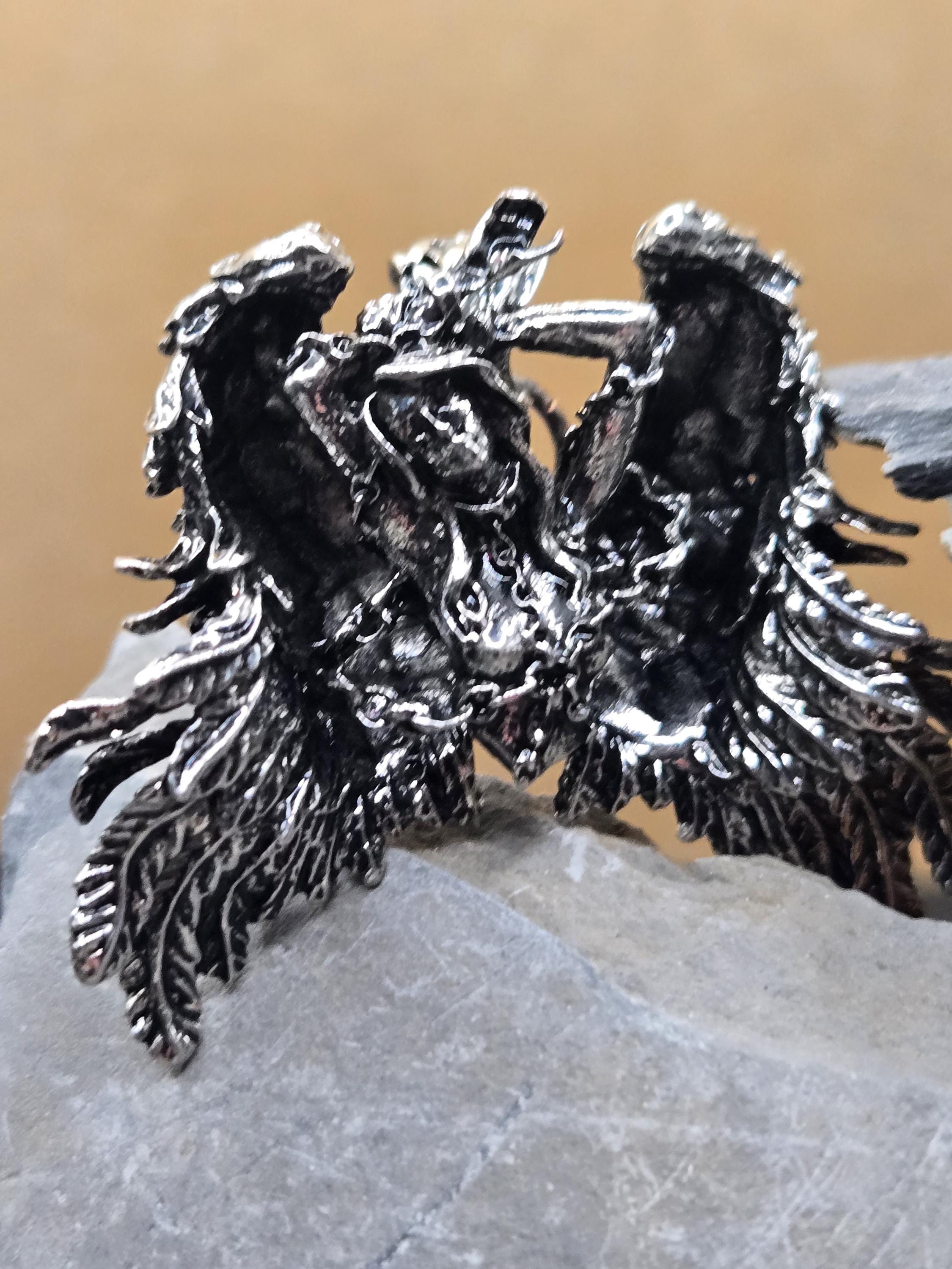 a close-up view of a metallic, intricate piece of jewelry, possibly a ring or a necklace, with a textured, ornate design.