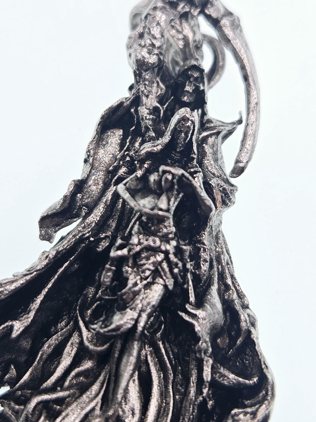 A close-up view of a detailed, textured metal sculpture with a twisted, organic shape.