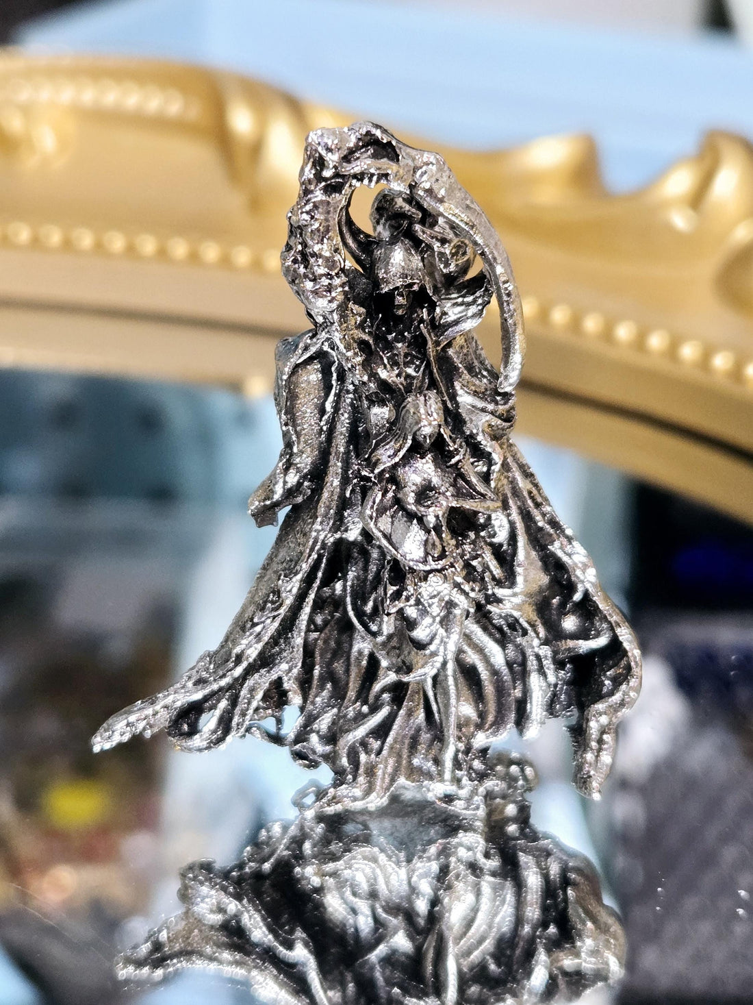 A close-up view of a detailed, textured metal sculpture with a twisted, organic shape.