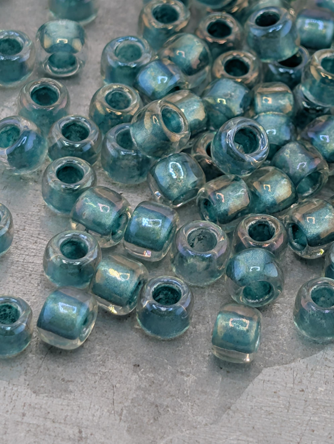 a collection of small, clear glass beads scattered on a surface.