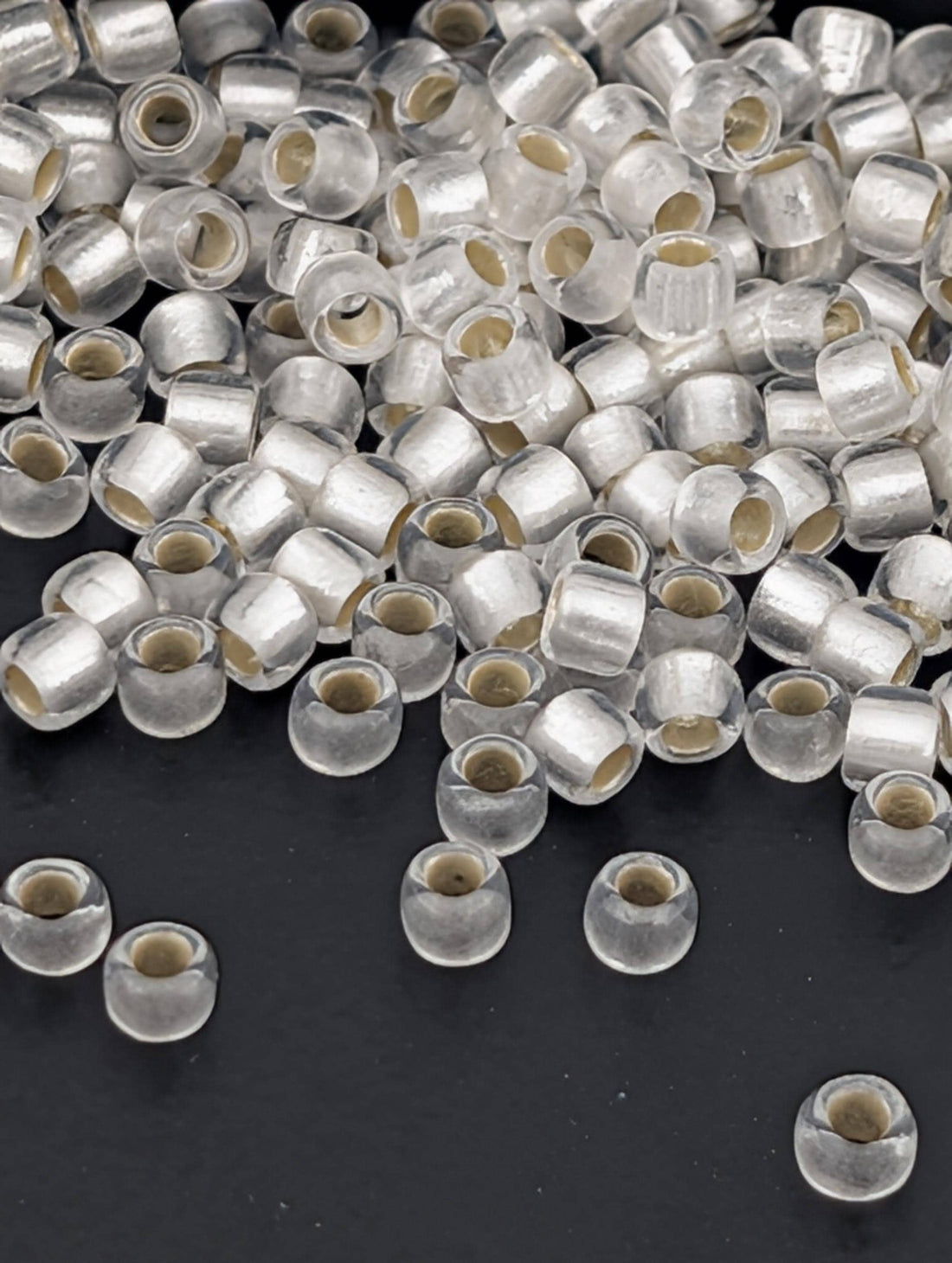 a collection of clear beads scattered on a dark background.