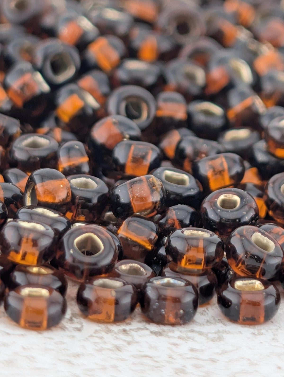 a close-up view of numerous brown and orange glass beads scattered on a surface.