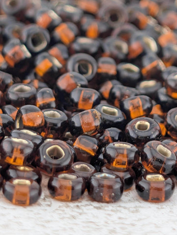 a close-up view of numerous brown and orange glass beads scattered on a surface.
