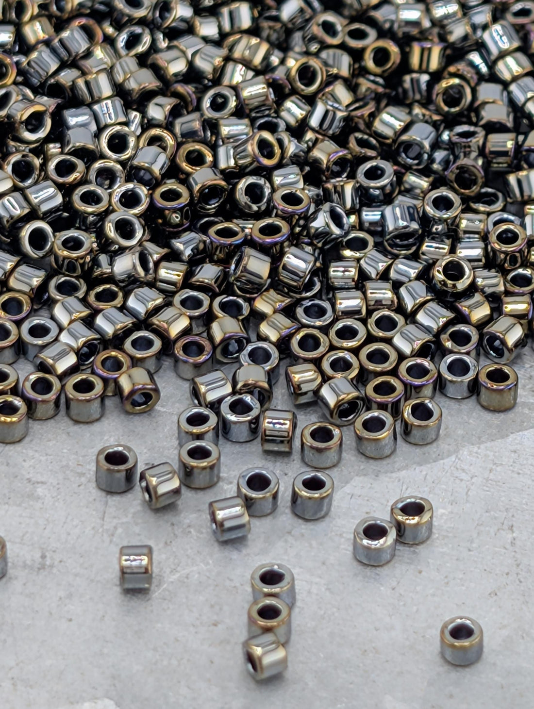 a large pile of small, shiny metal beads or nuts scattered on a surface.