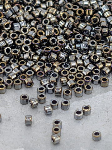a large pile of small, shiny metal beads or nuts scattered on a surface.