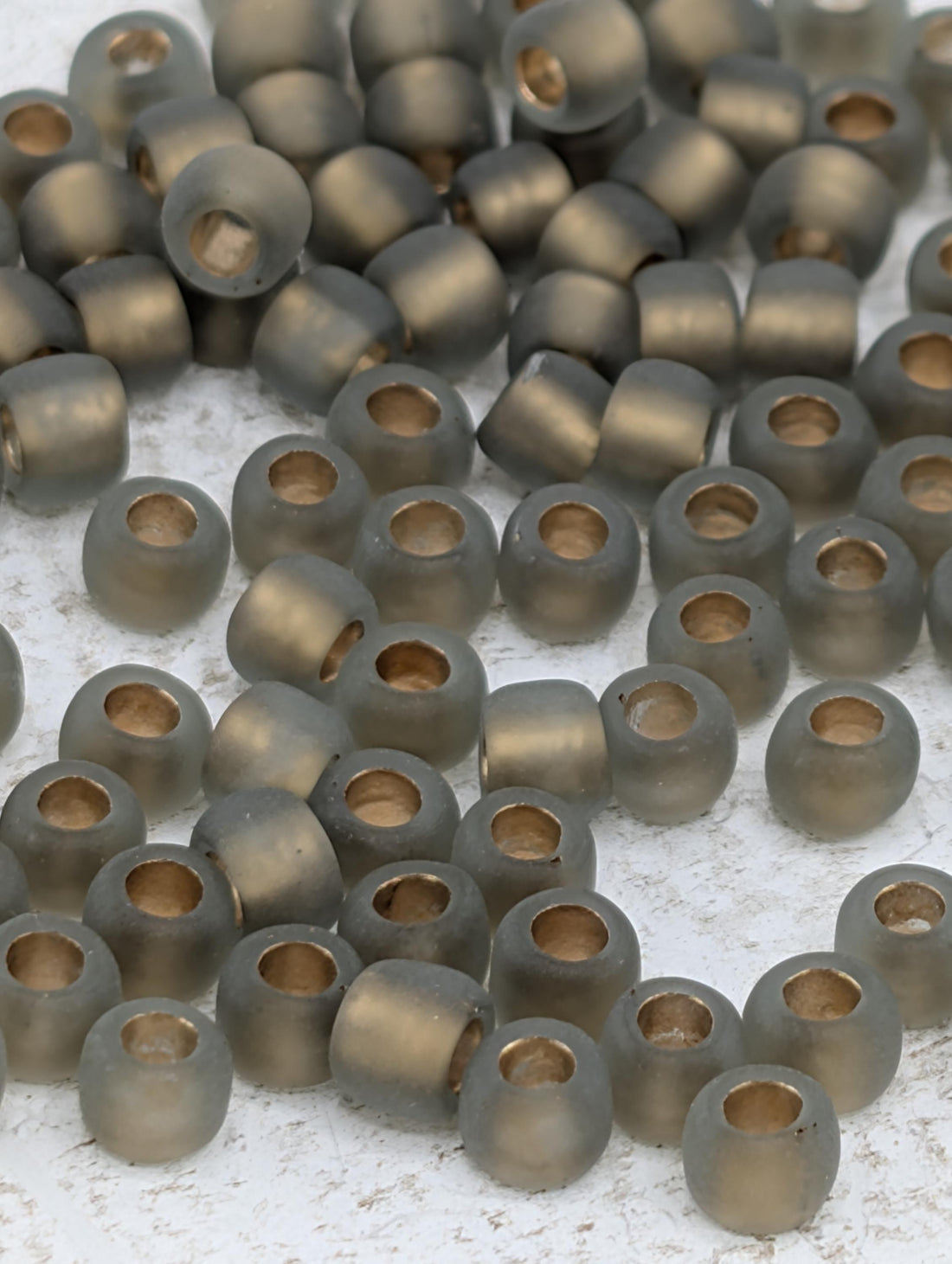 a collection of small, round beads in various shades of gray, scattered across a white surface.