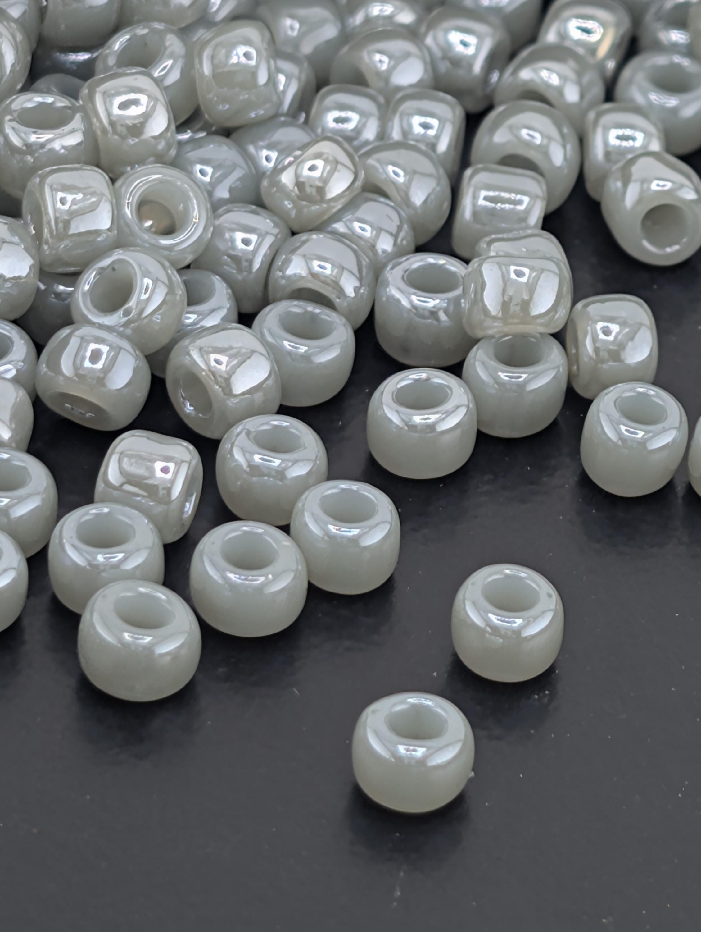 a collection of small, white beads scattered on a dark surface.