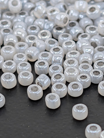 a collection of small, white beads scattered on a dark surface.