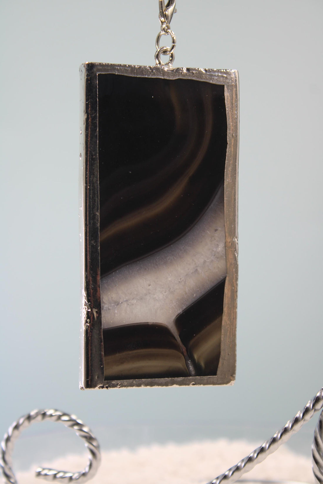 a rectangular, black-colored object with a silver frame, placed on a white surface.