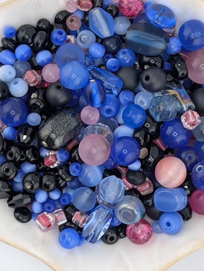 a variety of colorful glass beads in shades of blue, black, and pink, arranged in a visually appealing manner.