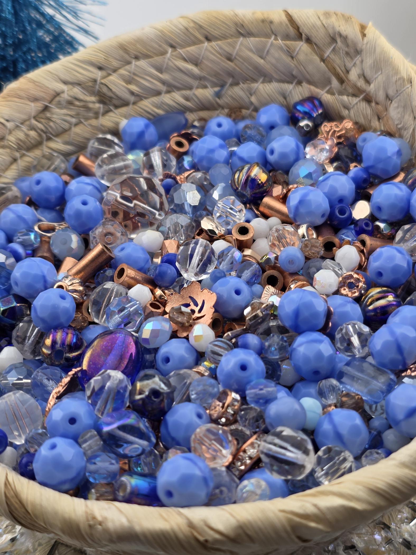 A basket filled with various blue and copper-colored beads, including clear and multicolored glass beads.