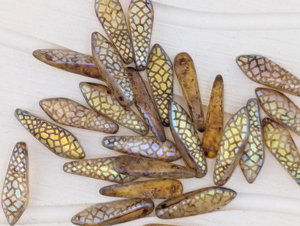 a collection of various colored glass beads scattered on a white surface.