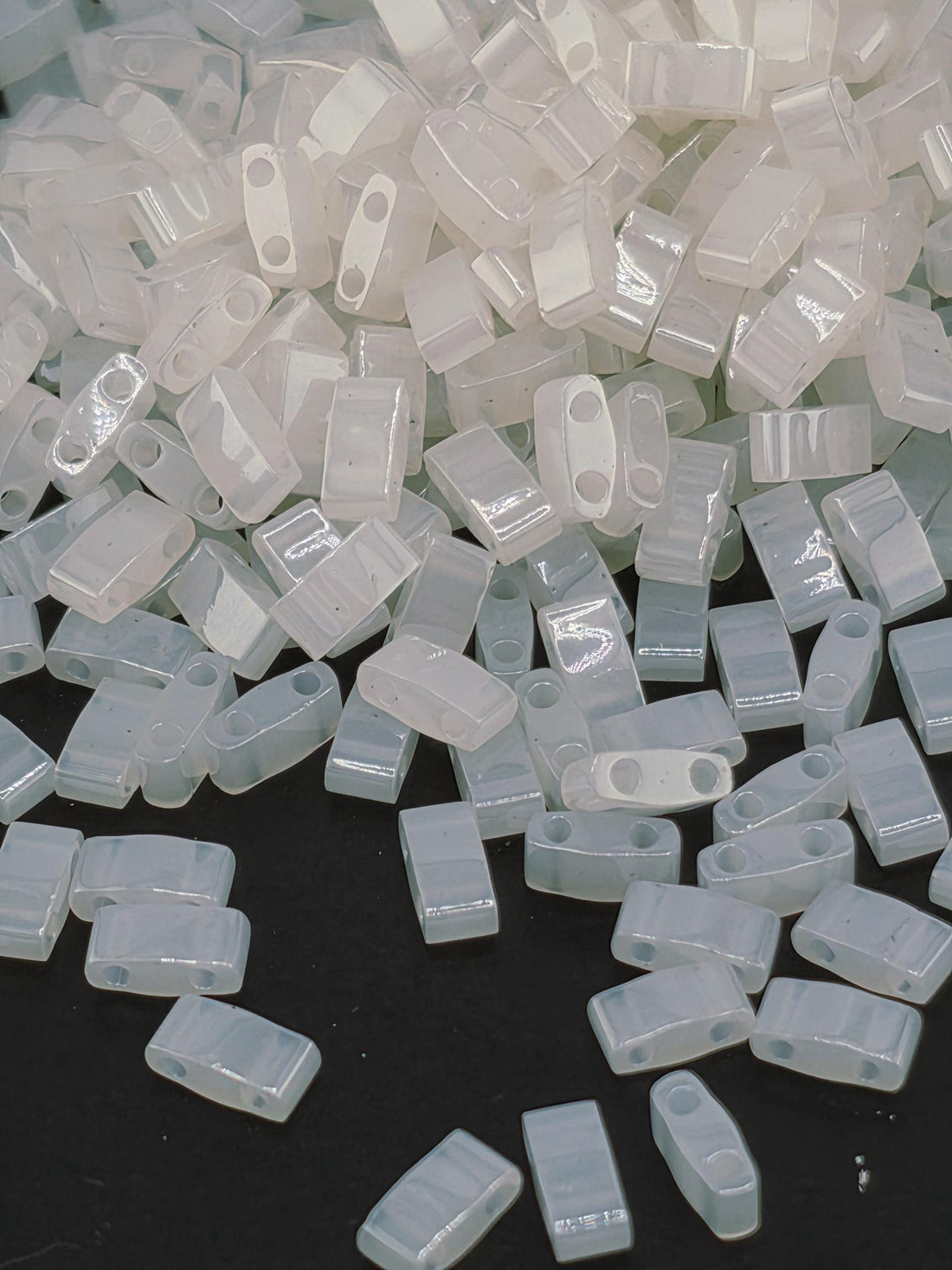 numerous small, clear plastic pieces scattered across a dark background.