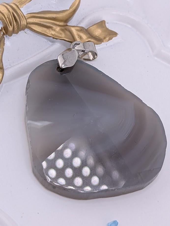 A necklace with a large, irregularly shaped stone pendant hanging from a silver chain.