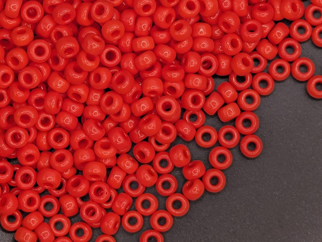 A large pile of red plastic beads scattered on a dark surface.