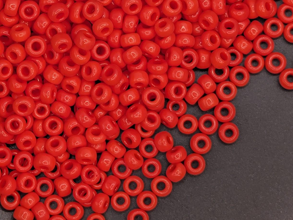 A large pile of red plastic beads scattered on a dark surface.