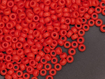 A large pile of red plastic beads scattered on a dark surface.