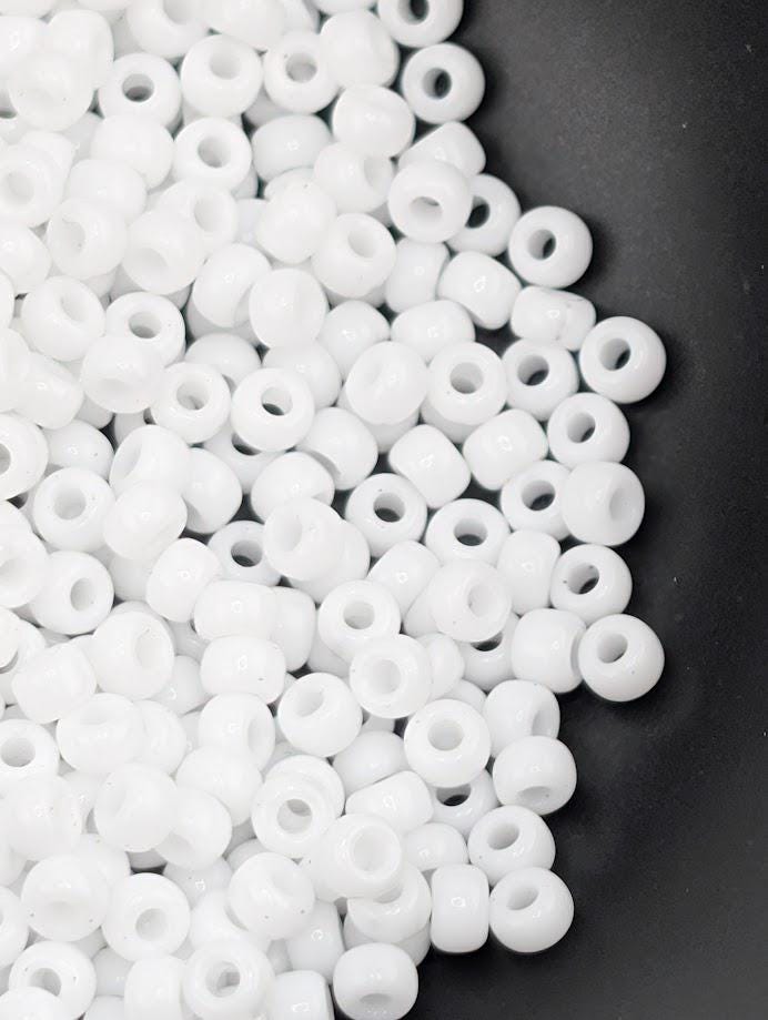 a close-up view of numerous white beads scattered on a black background.