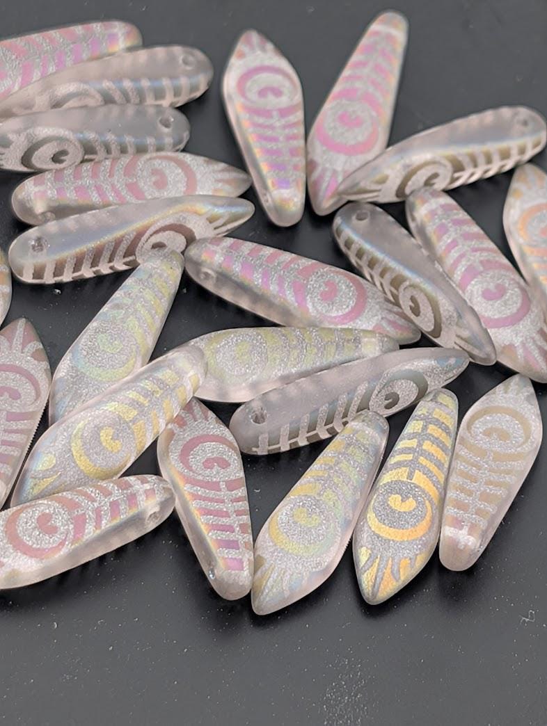 a collection of colorful glass beads scattered on a dark surface.