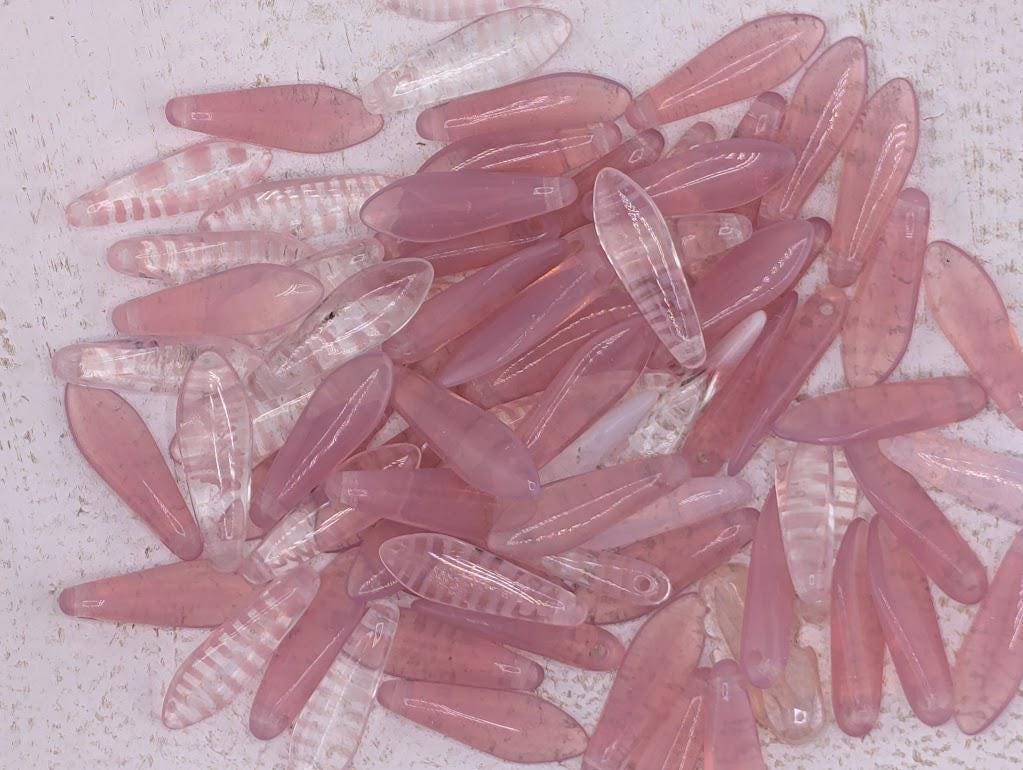 a collection of pink and clear beads scattered on a surface.