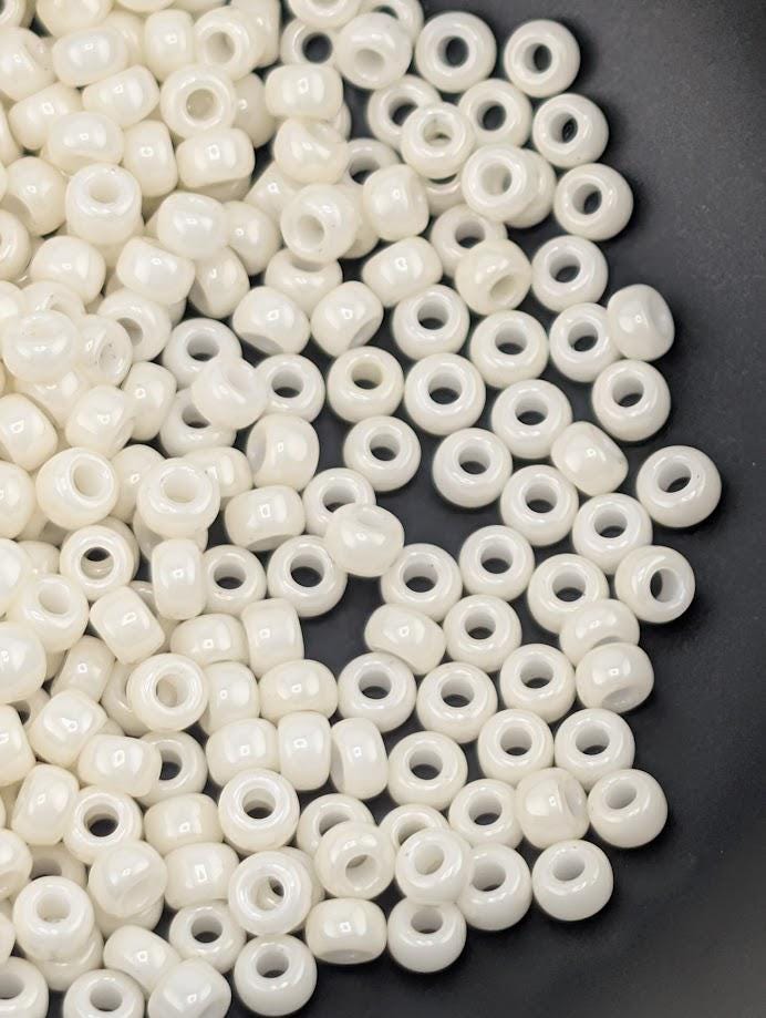 a close-up view of numerous small, white beads scattered on a dark surface.