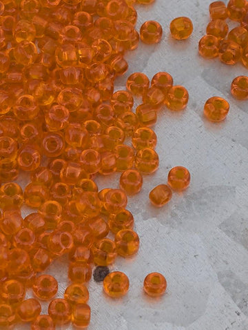 a collection of small, round orange beads scattered on a white surface.