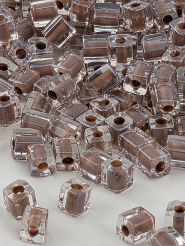 numerous clear glass beads scattered across a surface, with some of the beads overlapping each other.