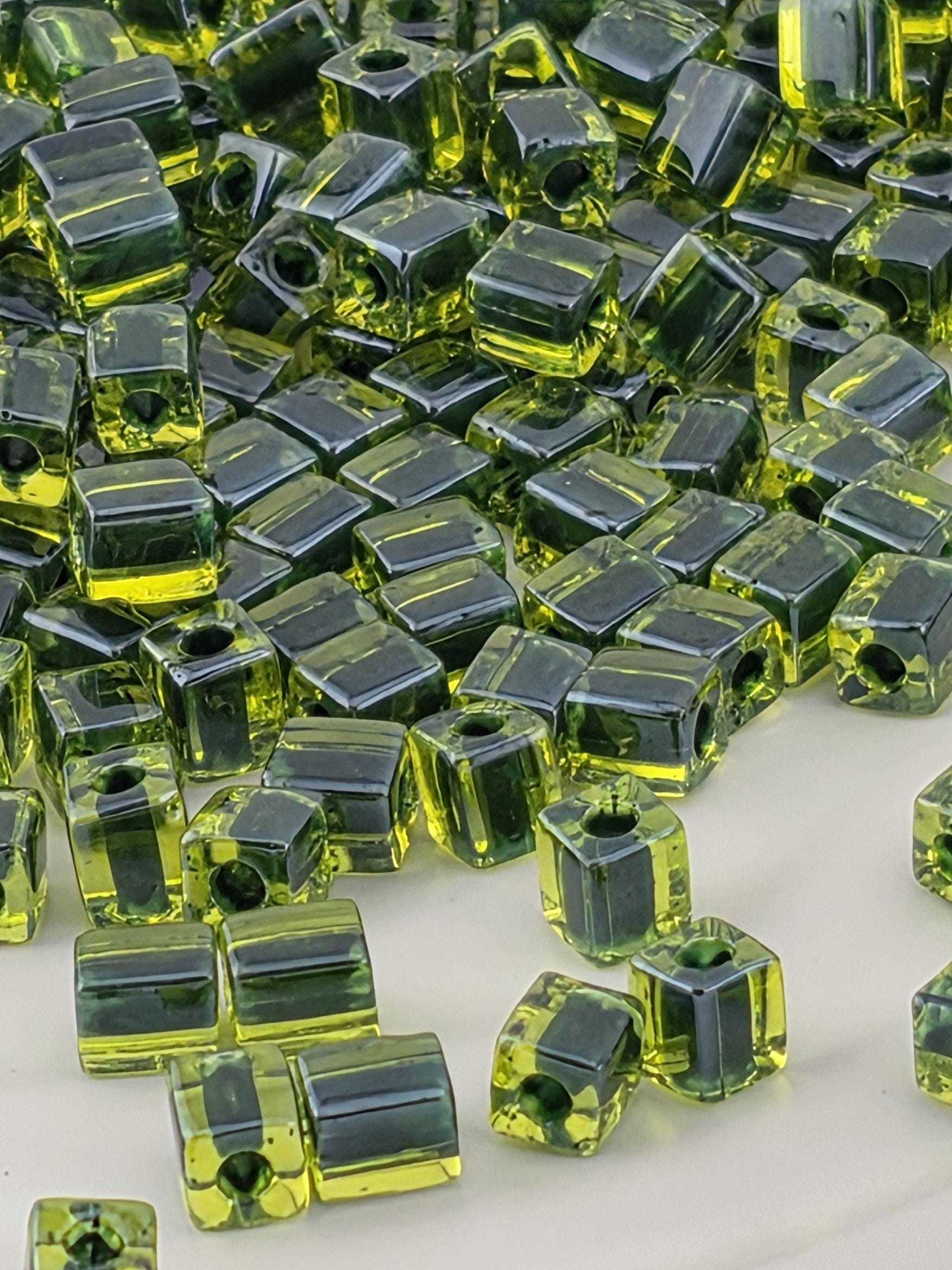 a close-up view of numerous green glass beads scattered across a surface.