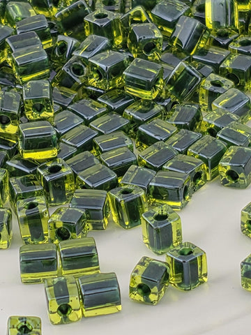 a close-up view of numerous green glass beads scattered across a surface.