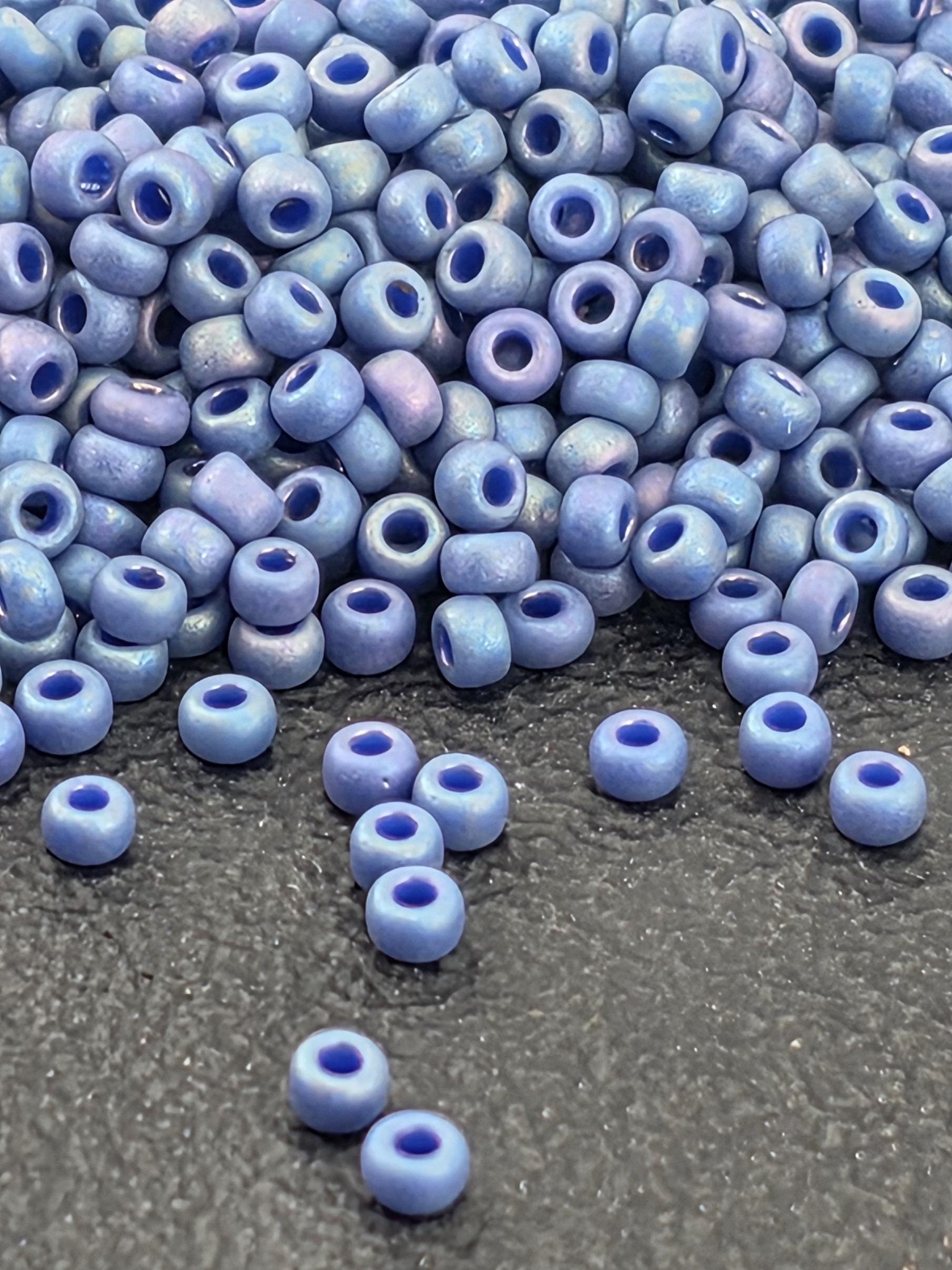 a pile of small, round blue beads scattered on a dark surface.