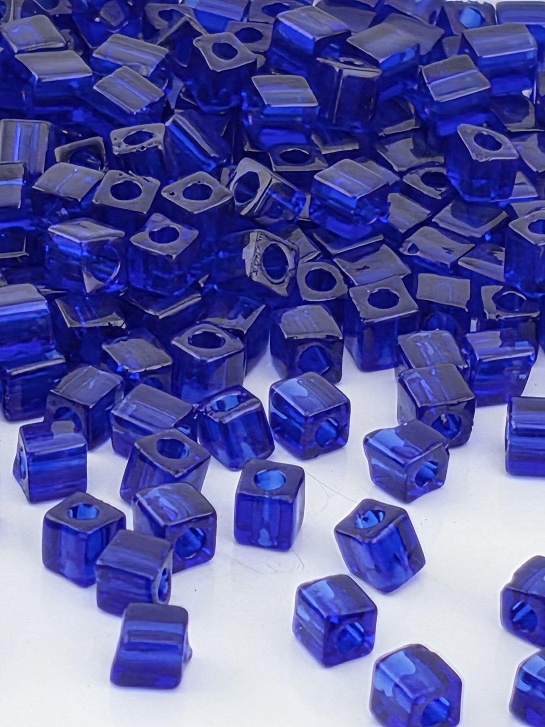 numerous blue glass beads scattered across a surface, creating a visually striking and vibrant display.