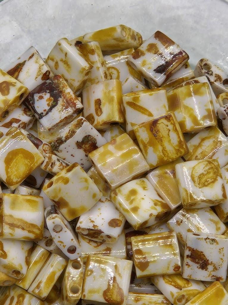 a close-up view of a pile of small, irregularly shaped, yellow and brown beads or stones.