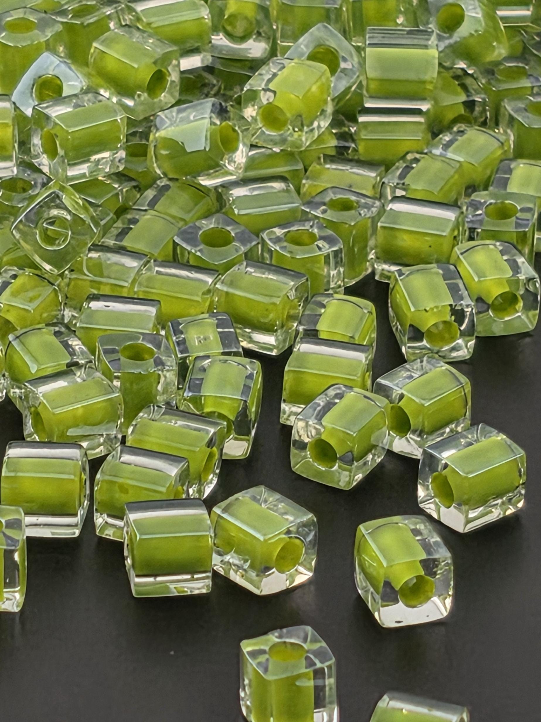 numerous transparent, hexagonal-shaped objects with a vibrant green color, scattered across a dark background.
