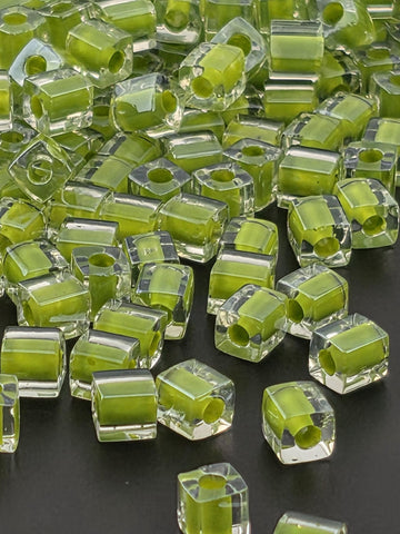 numerous transparent, hexagonal-shaped objects with a vibrant green color, scattered across a dark background.