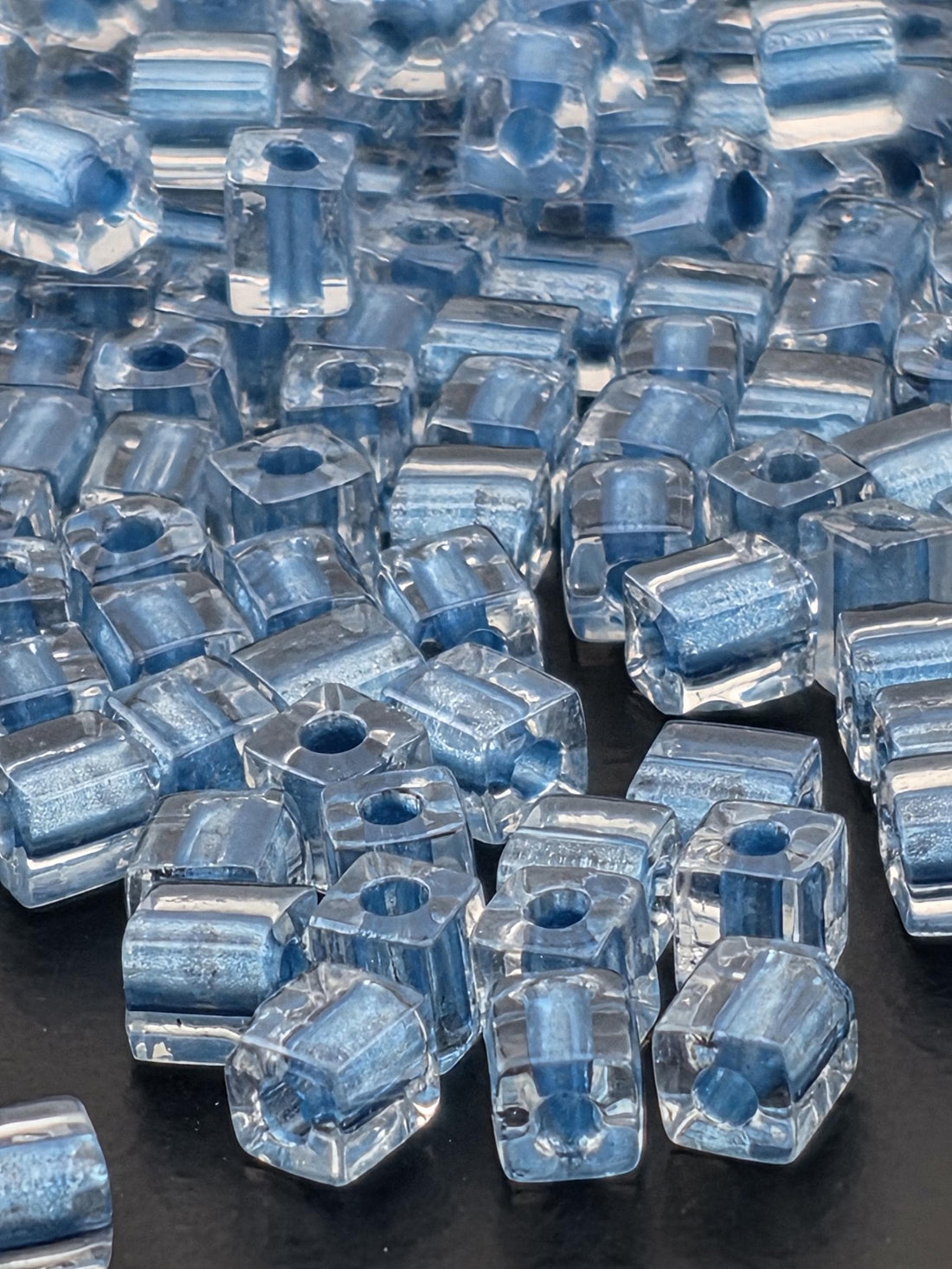 numerous clear glass beads scattered across a dark background.