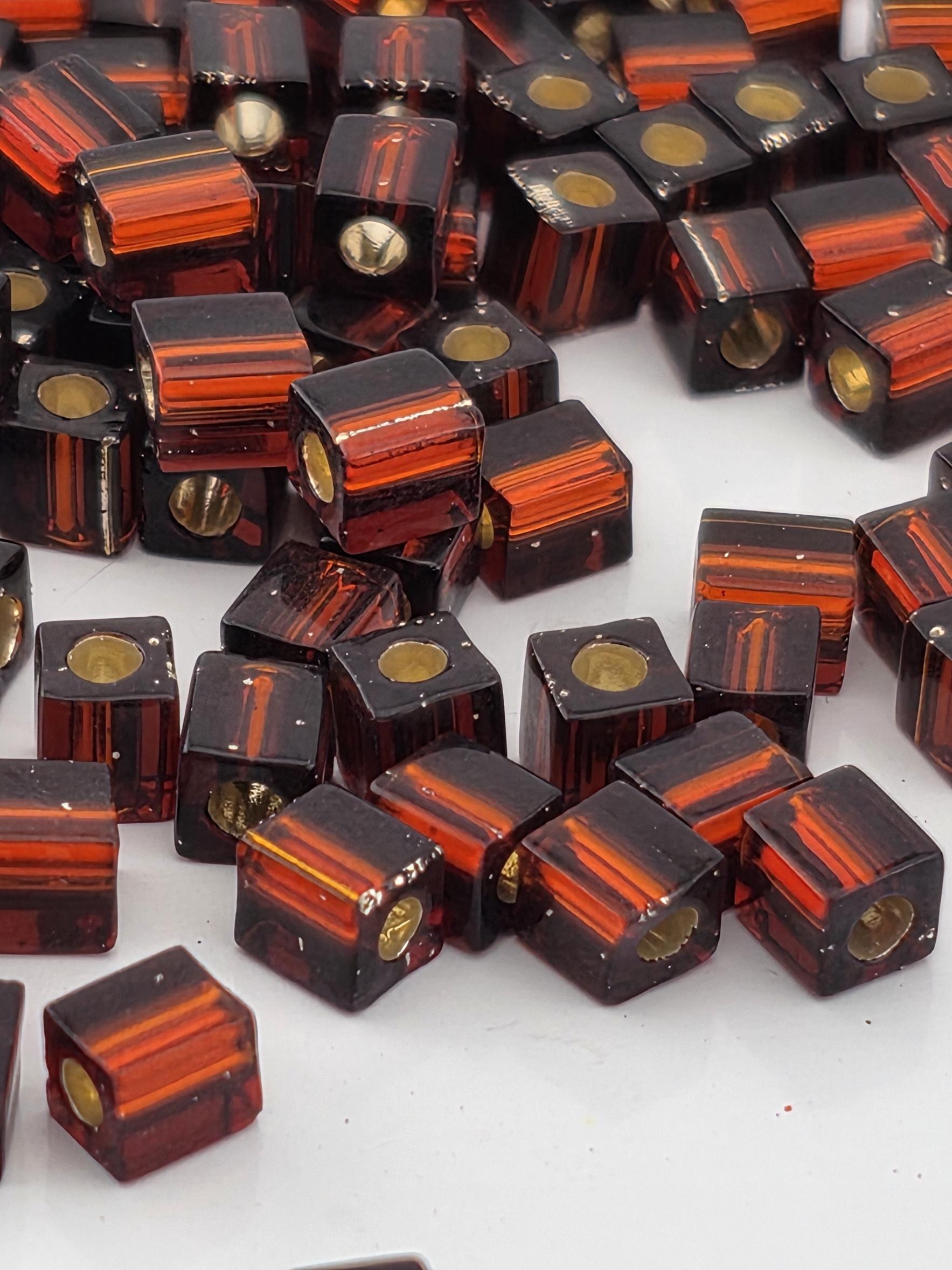 a collection of small, square-shaped objects with a dark orange and black color scheme, scattered on a white background.