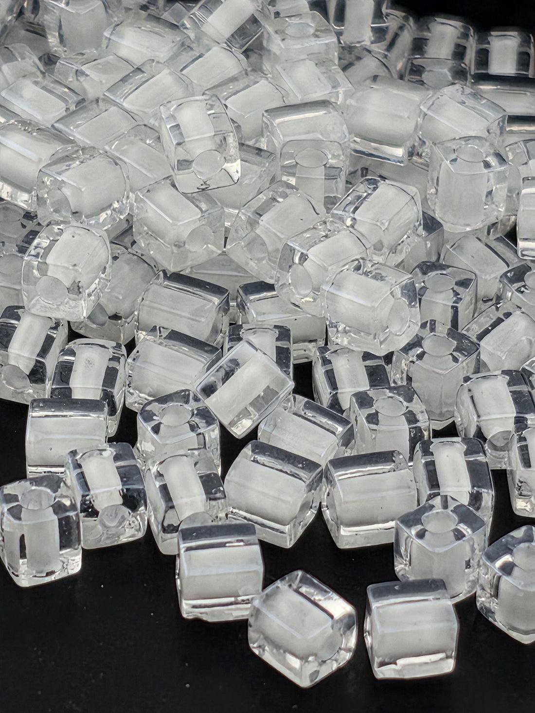 a close-up view of numerous clear, transparent cubes or blocks of a material, possibly glass or plastic, arranged in a visually interesting manner.
