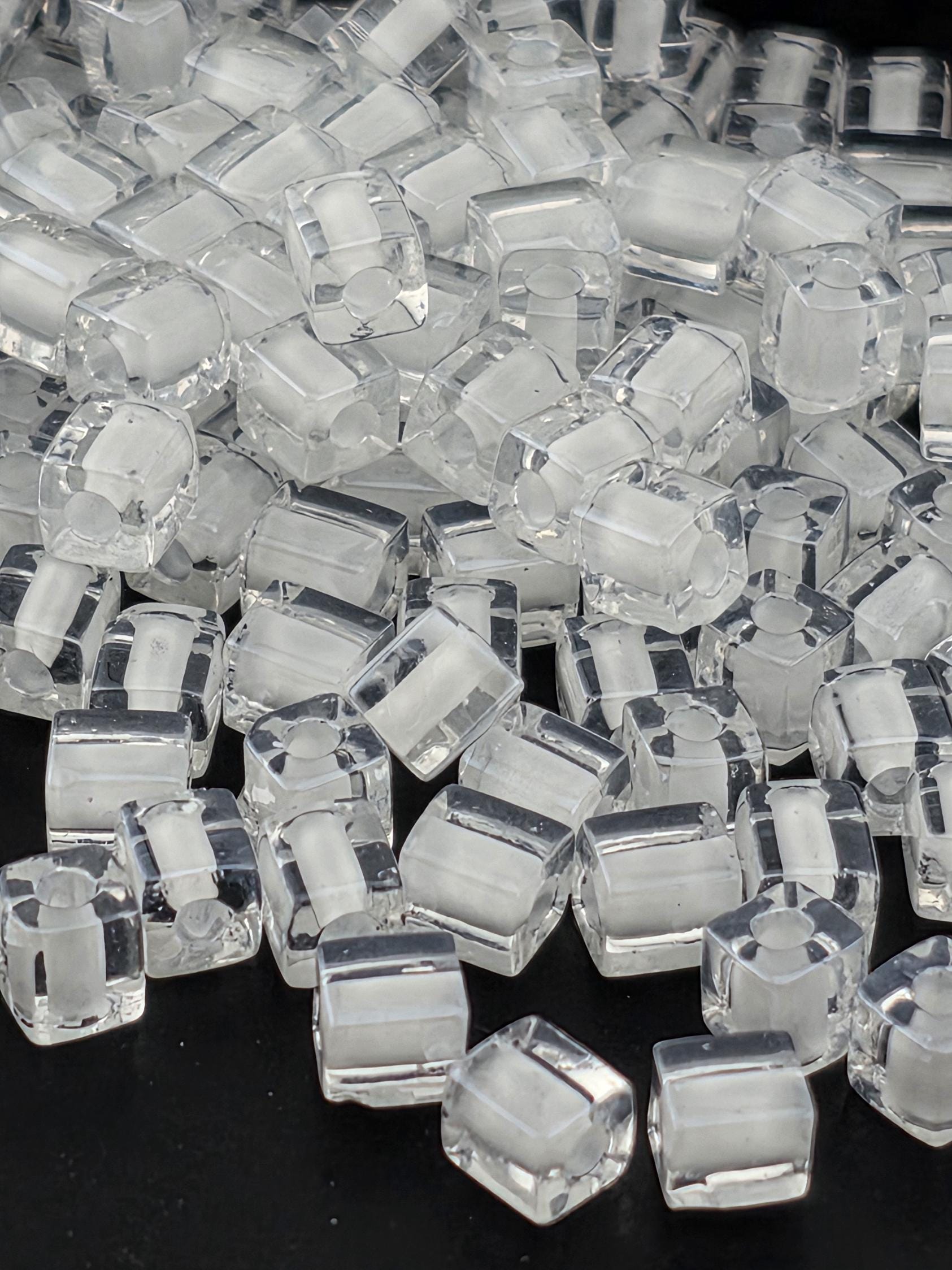 a close-up view of numerous clear, transparent cubes or blocks of a material, possibly glass or plastic, arranged in a visually interesting manner.