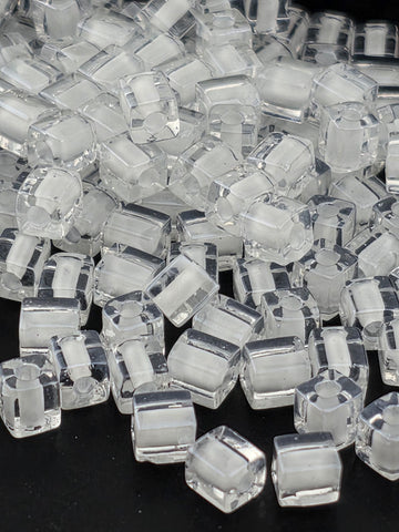 a close-up view of numerous clear, transparent cubes or blocks of a material, possibly glass or plastic, arranged in a visually interesting manner.