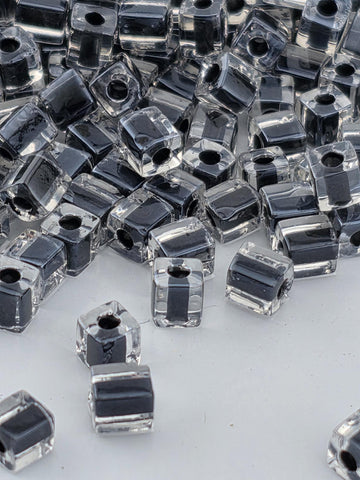 a collection of clear glass beads scattered across a white surface.