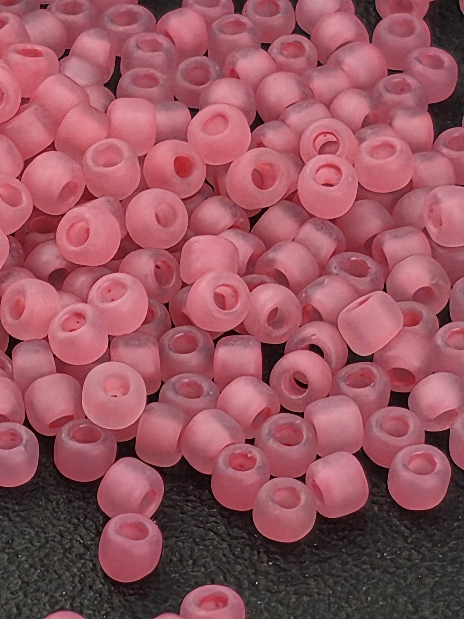 A close-up image of numerous pink beads or beads arranged in a pile.