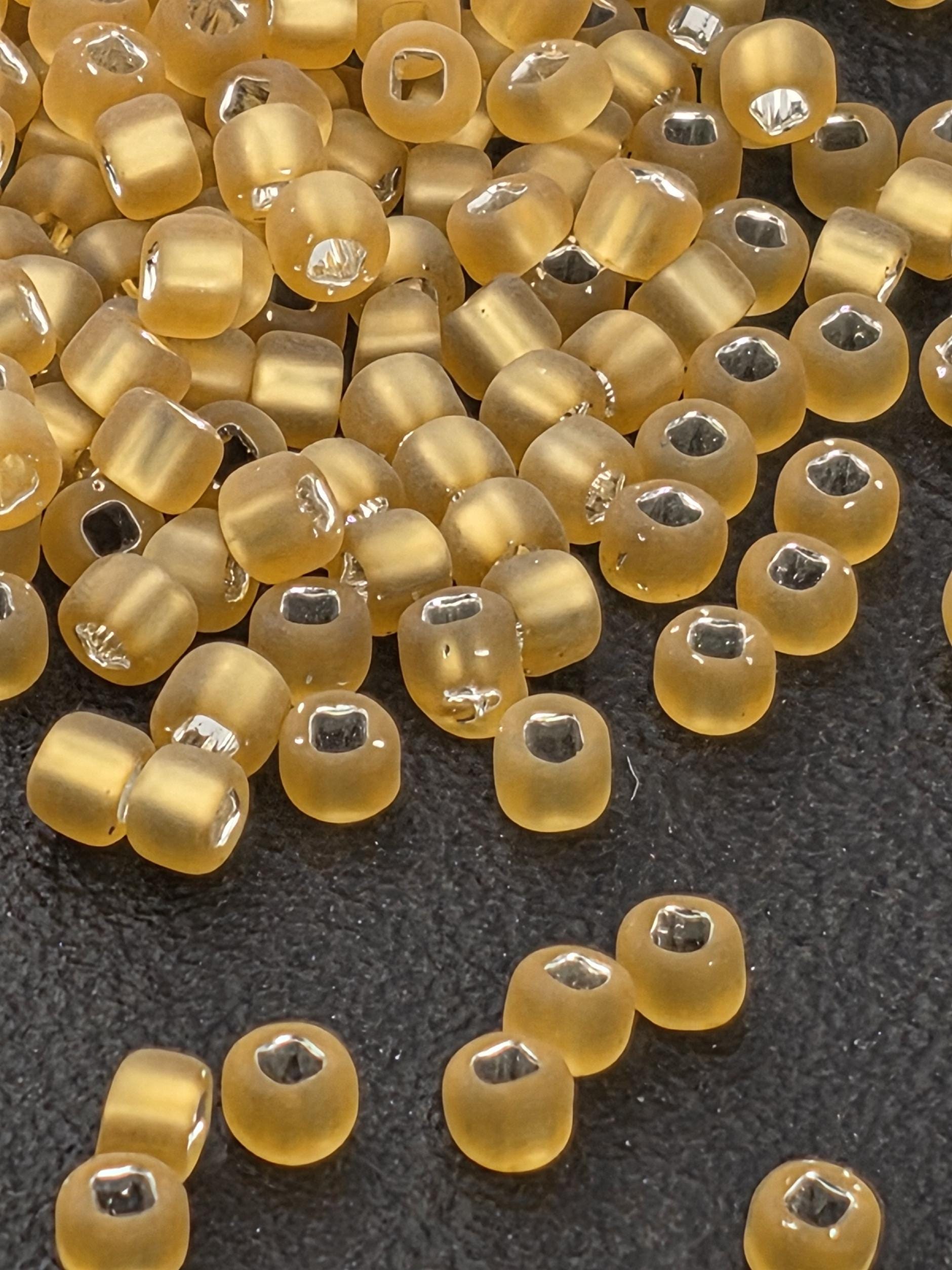 a collection of small, round, yellow beads scattered on a dark surface.