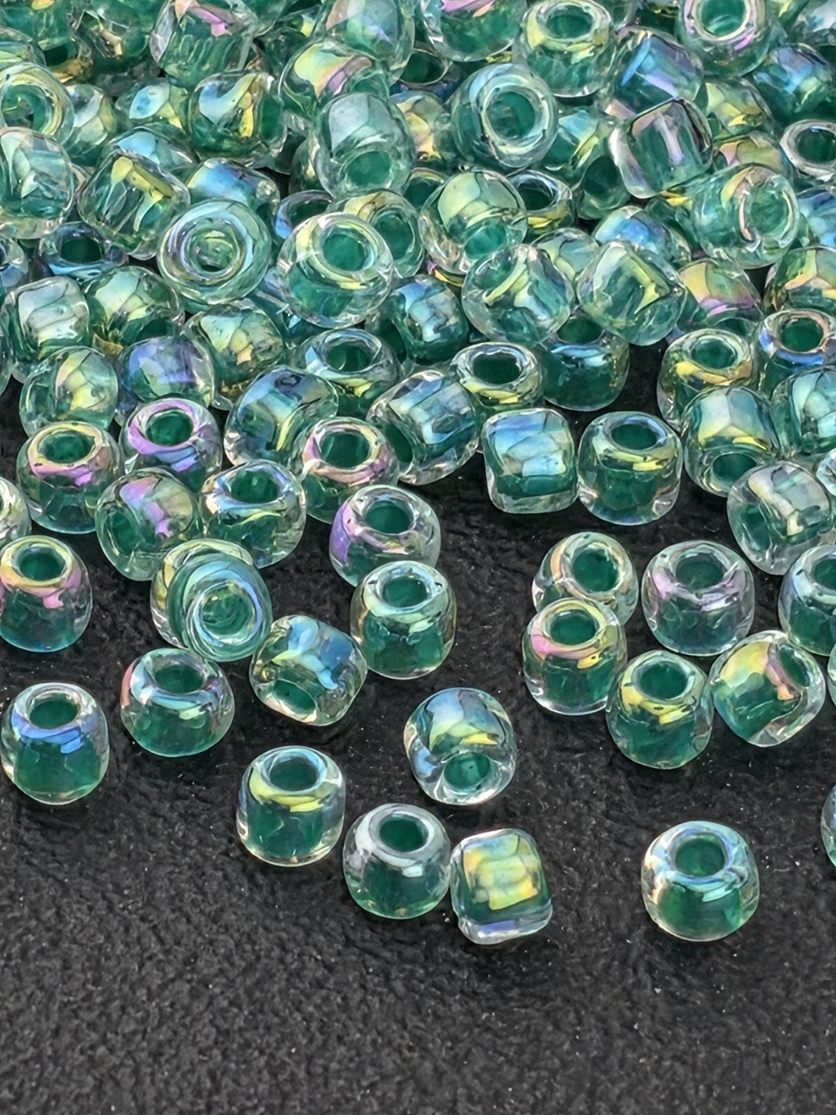 a collection of clear glass beads scattered on a dark surface.