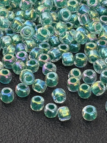 a collection of clear glass beads scattered on a dark surface.