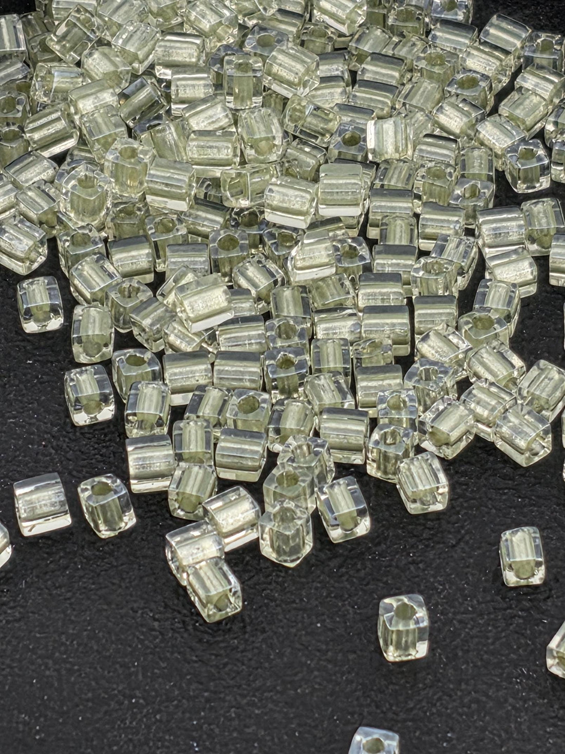 a collection of small, clear, and transparent objects scattered on a dark surface.