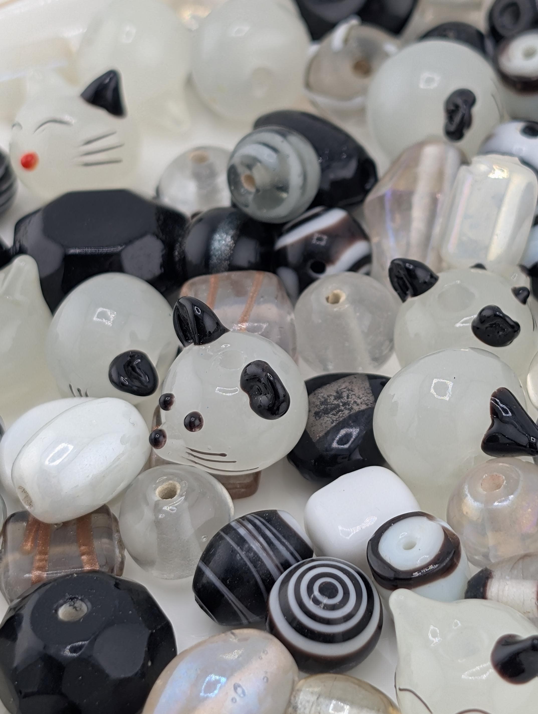 a variety of colorful beads, including black, white, and multicolored beads, arranged in a visually appealing manner.